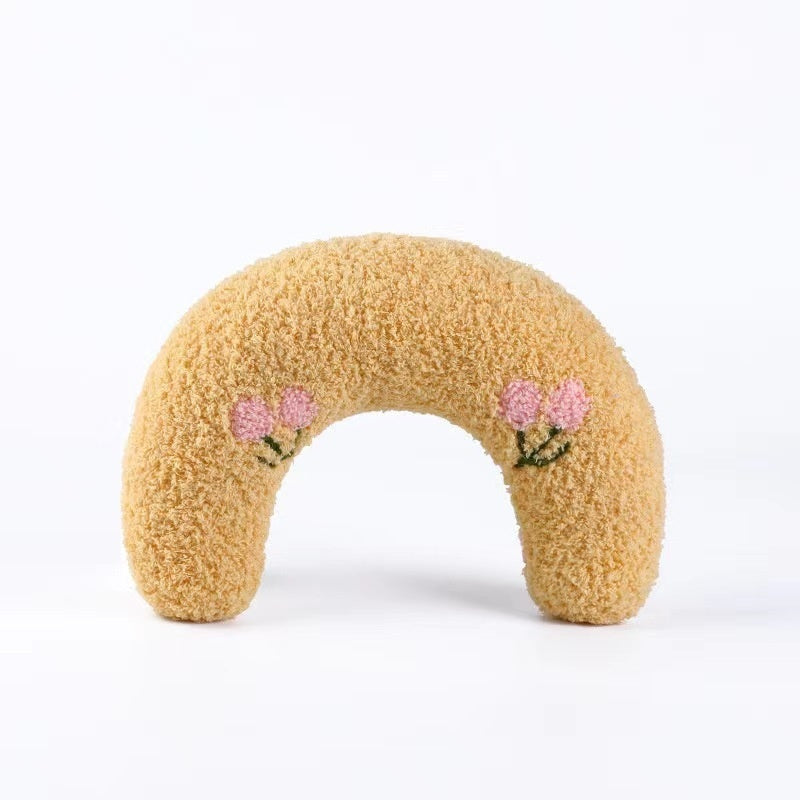 Beige plush U-shaped cat pillow toy with pink flower patches