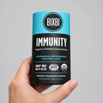 BIXBI Immunity daily pet supplement jar held in a hand, front label visible.