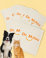 Stacked Dr. Milou pet dental wipe packs with orange logo print