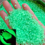 Bright green luminous glowing stones, small faceted pieces held in an open hand