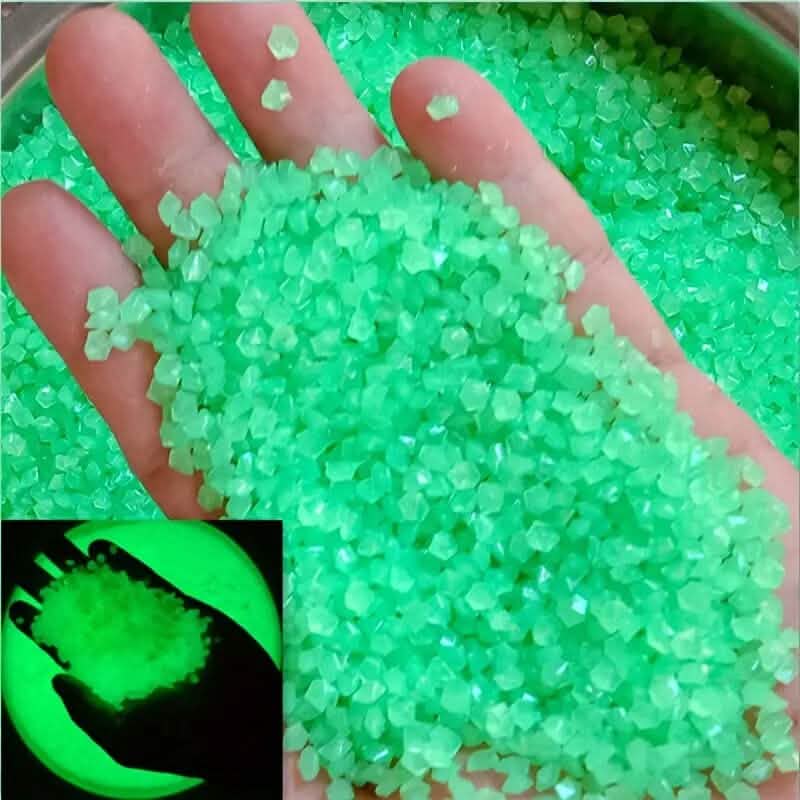 Bright green luminous glowing stones, small faceted pieces held in an open hand