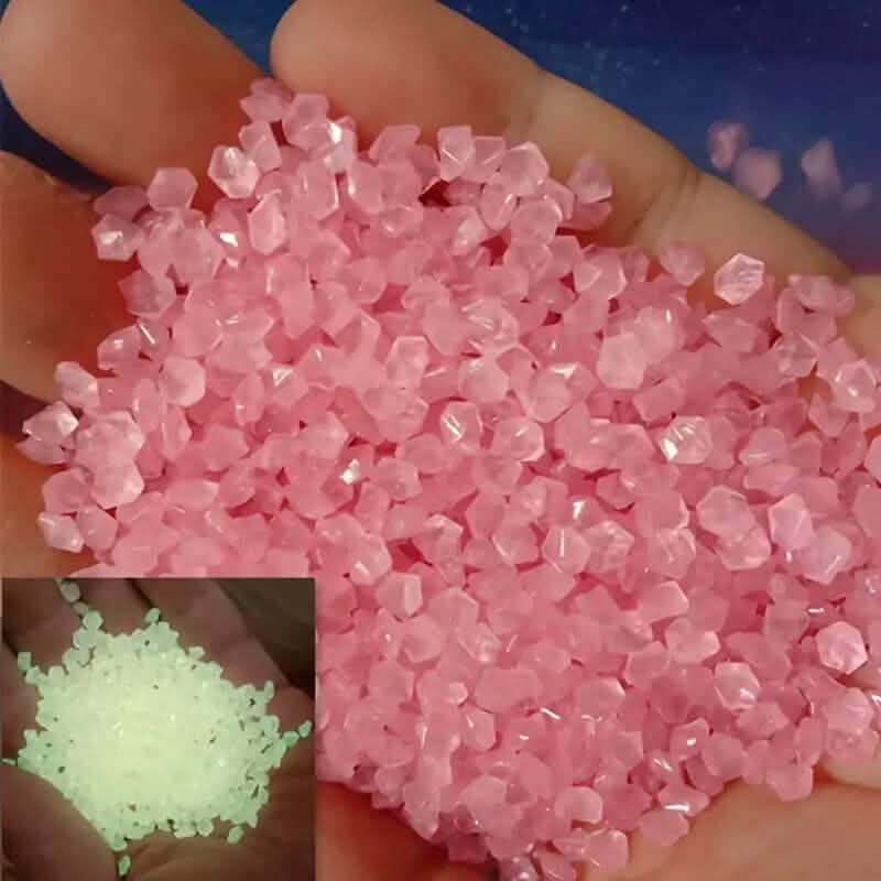 Pink luminous glowing stones, small faceted pieces held in an open hand