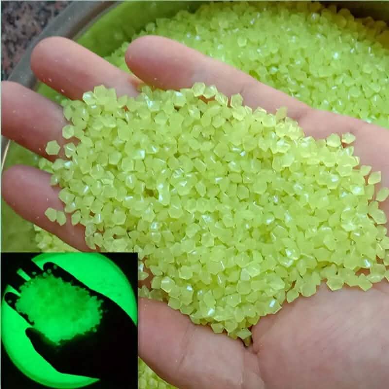 Lime yellow luminous glowing stones, small faceted pieces held in an open hand