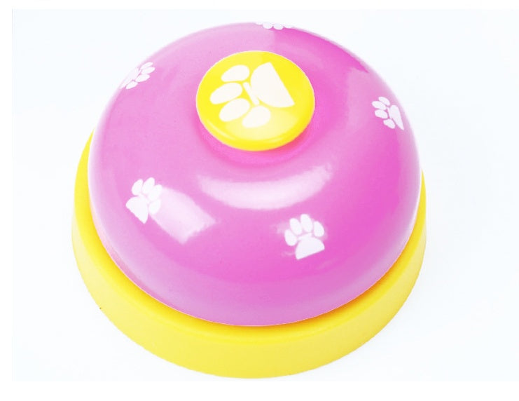 Pink paw press pet training bell with yellow button and paw-print detail