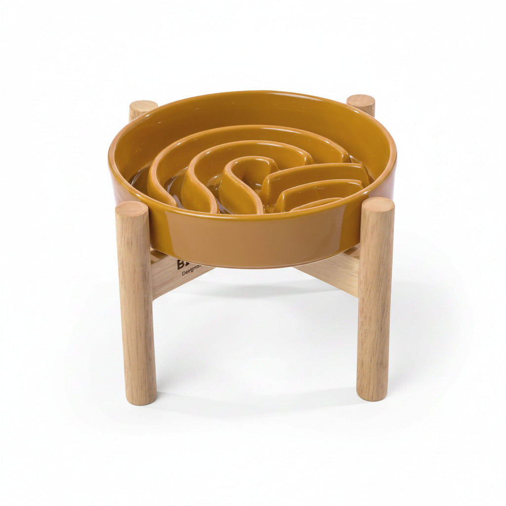 Orange wave slow feeder dog bowl on a wood stand with raised channels