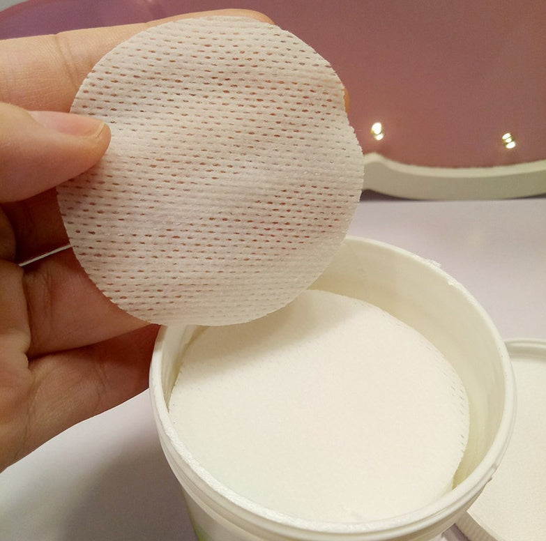 Round pet eye wipe pad pulled from container, showing textured surface