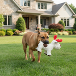 White plush animal doll with red accents and brown muzzle, held by a dog