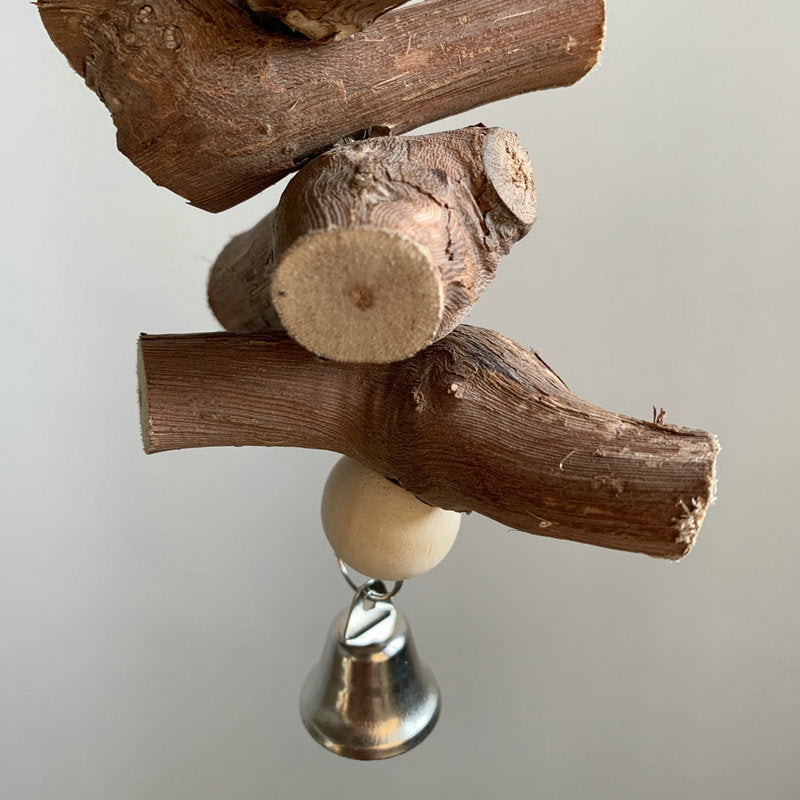 Wooden parrot molar toy bell with metal clapper, attached to curved vine log pieces