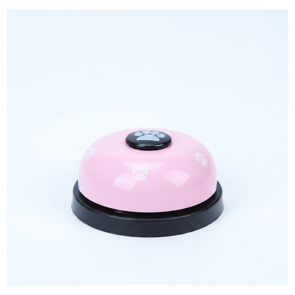 Pink pet training bell with black base and paw-print button on top