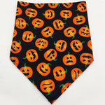Pet triangle bandana in black with orange jack-o’-lantern faces and spooky symbols