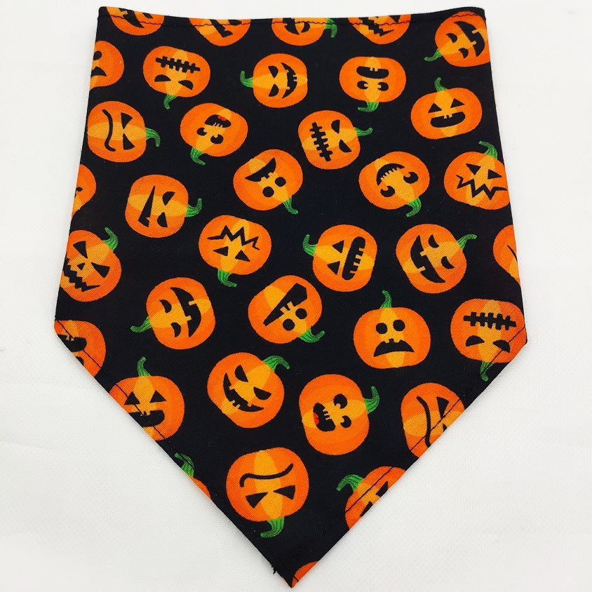 Pet triangle bandana in black with orange jack-o’-lantern faces and spooky symbols