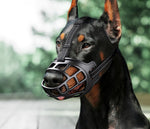 Black anti-bite dog muzzle with metal cage, shown on a medium-sized dog