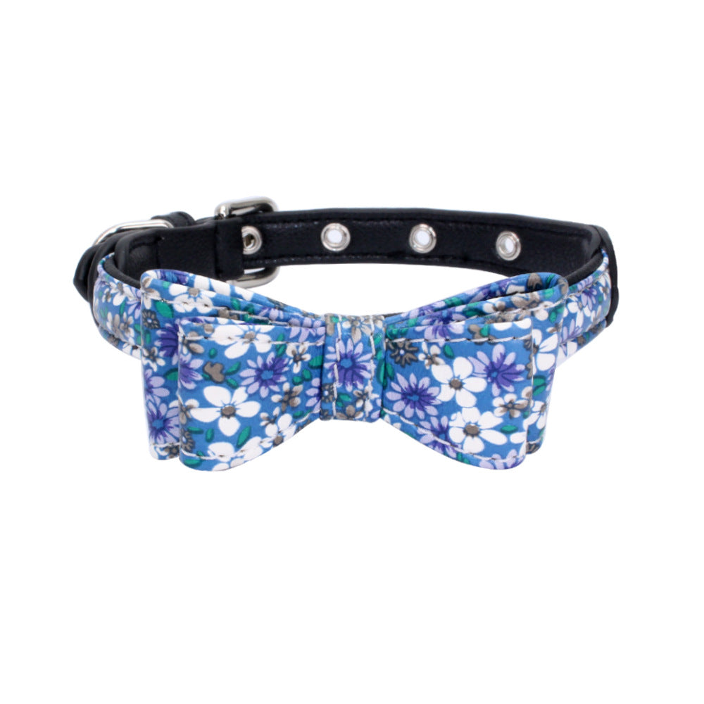 Blue floral pet collar with bow, and silver grommet studs on a dark collar