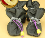 Dark gray soft dog boots with purple laces and yellow sole studs