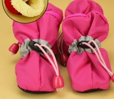 Pink soft dog boots with lace-up cords and red pull tabs, close-up pair