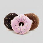 Plush donut dog toys in dark brown, pink, and brown with sprinkles and center hole