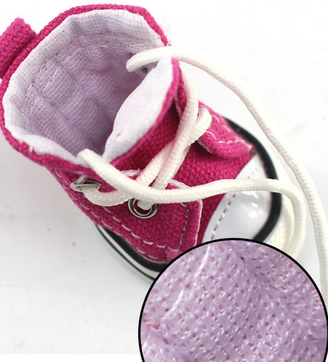 Pink canvas dog shoe with white laces and textured outsole detail