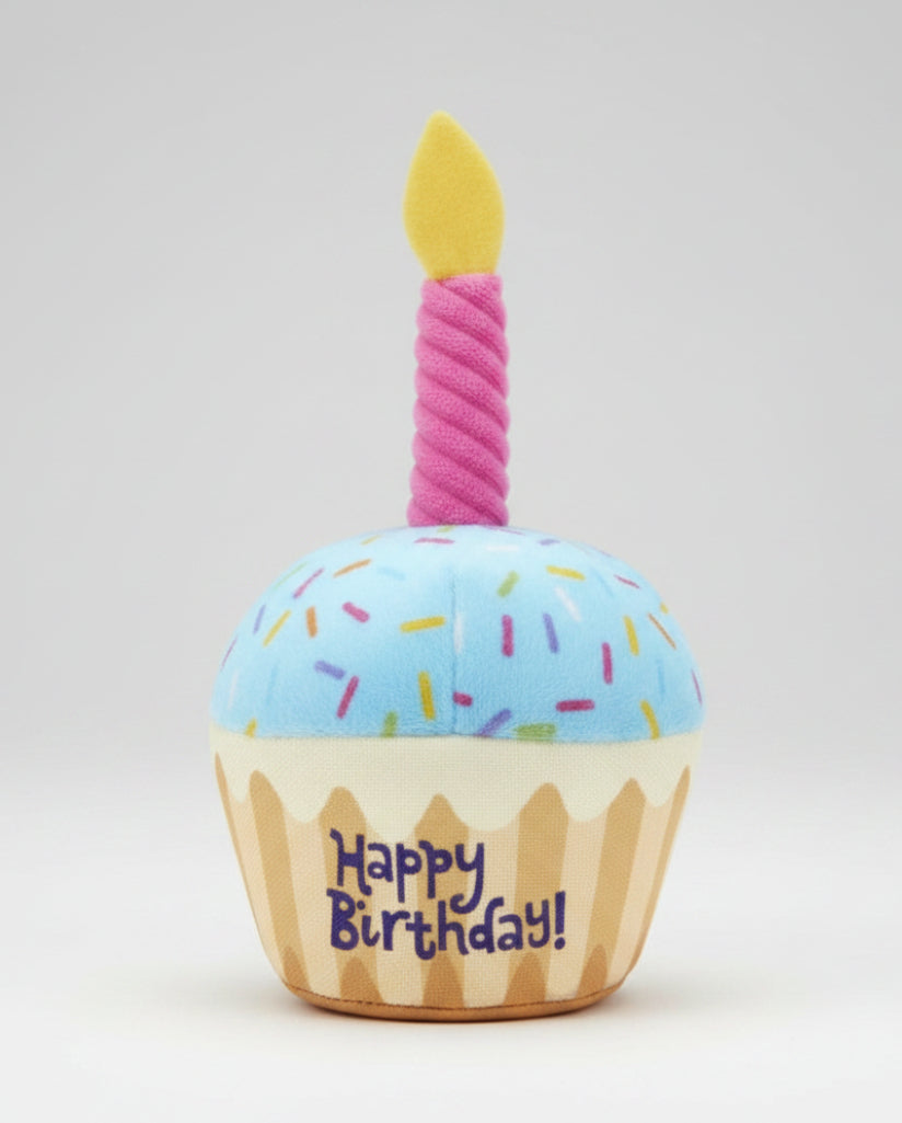 Plush birthday dog toy cupcake with blue top, pink candle, and 'Happy Birthday' print