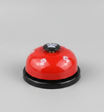 Red pet training bell with black base and paw-print button on top