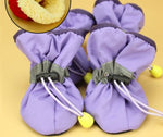 Lavender soft dog boots with white laces and yellow sole studs