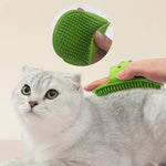 Green silicone pet massage brush being used on a gray cat