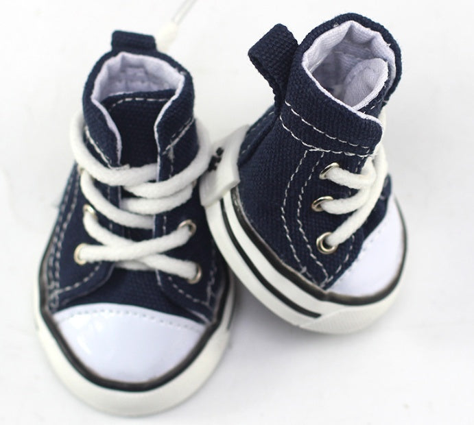 Pair of navy canvas dog shoes with white laces and padded ankle openings