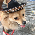 Black hot dog-style hat with patterned trim and faux fur top, worn by dog