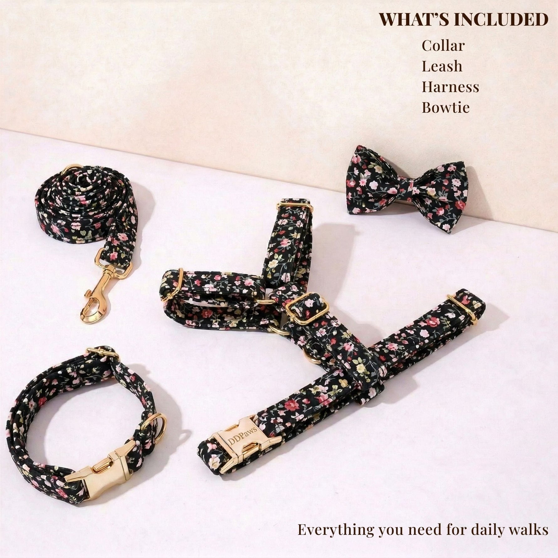Dog collar, leash and bowtie set in black with pink floral pattern, shown laid flat