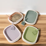 Multi-color anti-splash training trays with scoops in green and lilac; open box lids