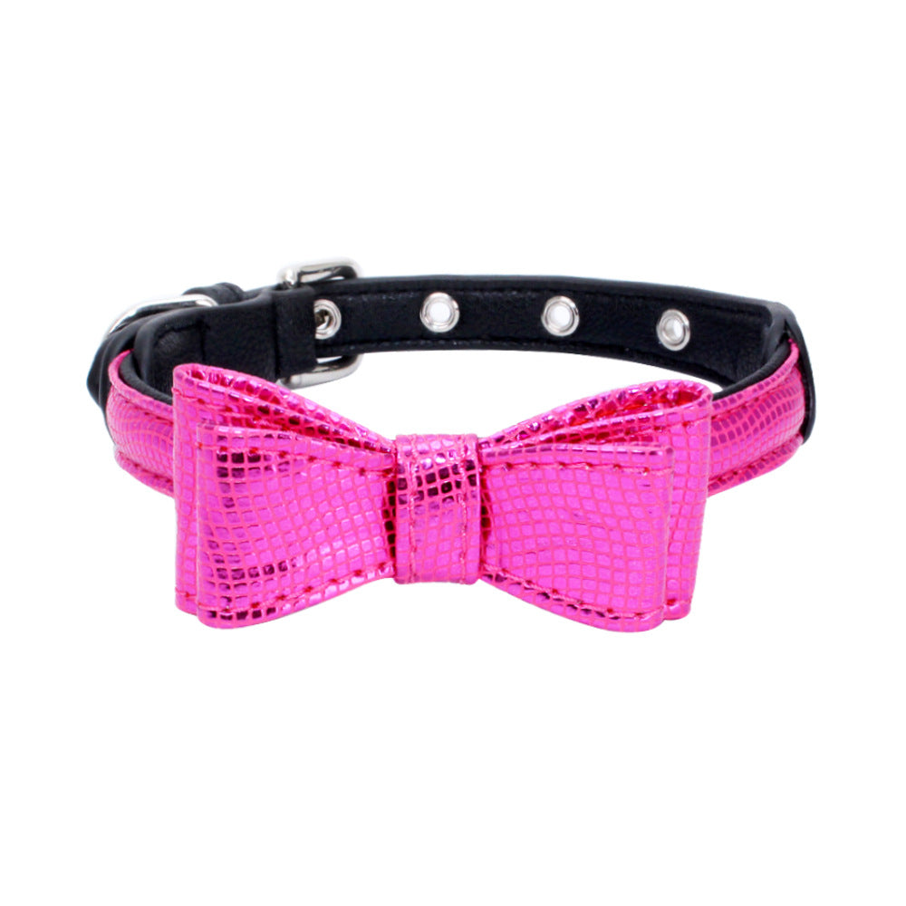 Pet collar with black strap and bright pink bow, textured finish, silver grommet studs