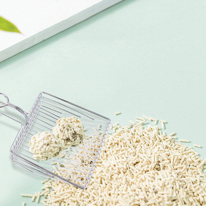 Wire mesh litter scoop holding light wood pellets, with loop handle