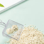 Wire mesh litter scoop holding light wood pellets, with loop handle