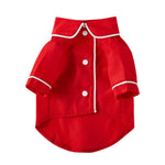 Small red pet dog jacket with white trim, snap buttons, and short cuffed sleeves