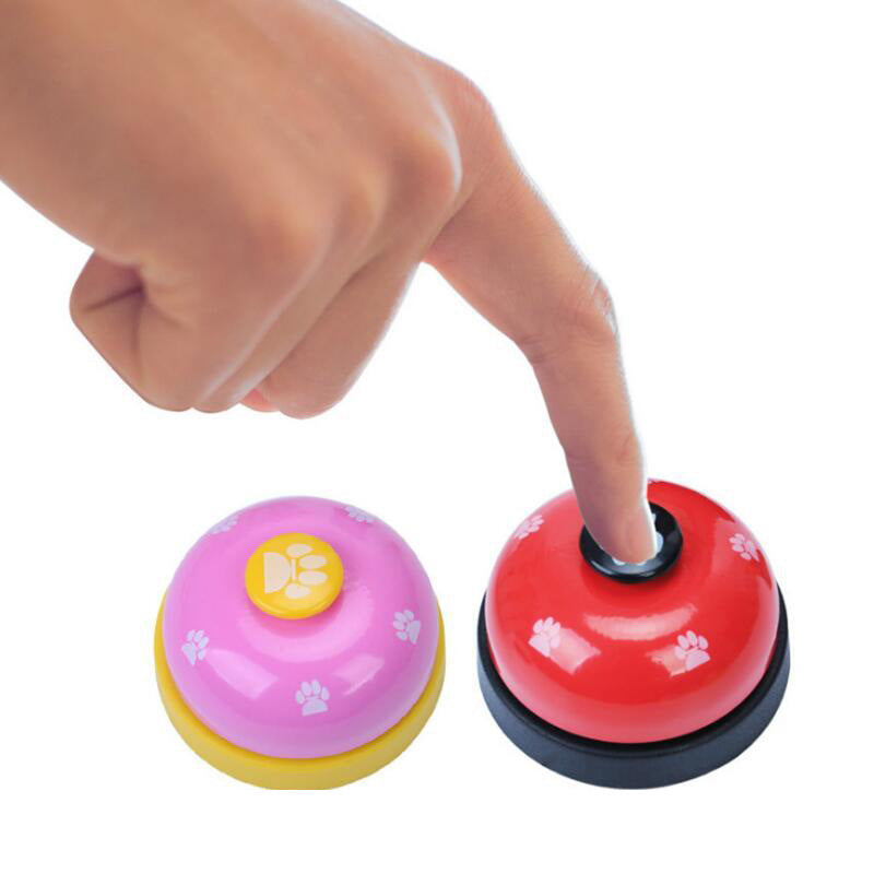 Pet training bell being pressed; pink and red domes with paw buttons