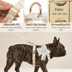 White satin harness with bowtie on dog, adjustable straps, and gold ID tag