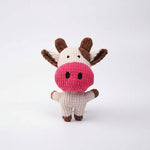 Plush cow squeaky dog toy with pink snout, white body, brown legs and ears