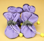 Lavender soft dog boots with lace-up cords and small yellow sole studs