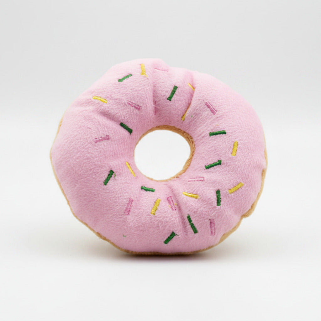 Pink plush donut dog toy with rainbow sprinkles and round center hole