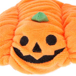 Close-up pumpkin pet hat: orange plush with stitched jack-o-lantern smile and green stem