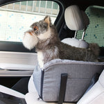 Grey travel pet car seat with zip front and adjustable strap on a car seat