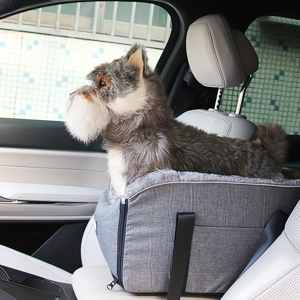 Grey travel pet car seat with zip front and adjustable strap on a car seat