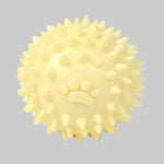 Spiky dog throwing ball toy with raised paw print, pale yellow