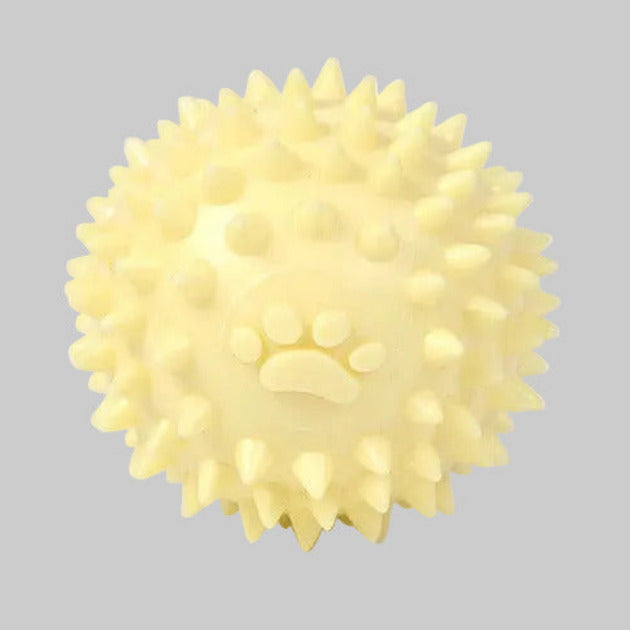Spiky dog throwing ball toy with raised paw print, pale yellow