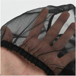 Black mesh seed catcher cover with elastic hem, held in hand
