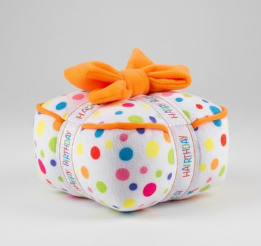 Plush birthday dog toy with orange bow and multicolor polka-dot fabric