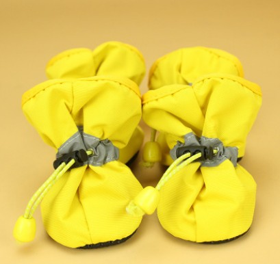 Pair of yellow dog warm boots with gray buckle straps and drawstring, soft soles