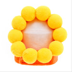 Sunflower-style plush pet hat with bright yellow petals and orange base