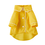 Small yellow pet dog jacket with white trim, snap buttons, and side pocket panels