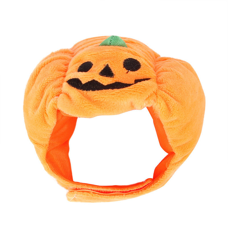 Orange pumpkin pet hat with jack-o-lantern face and small green stem, plush