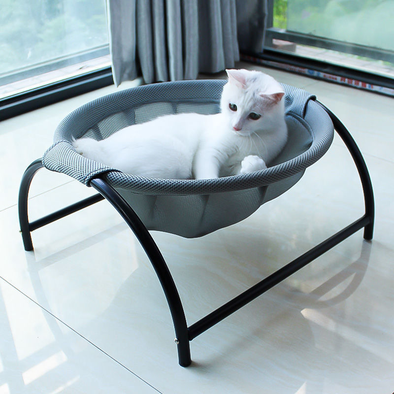 Light gray pet hammock bed with black frame, white cat resting inside